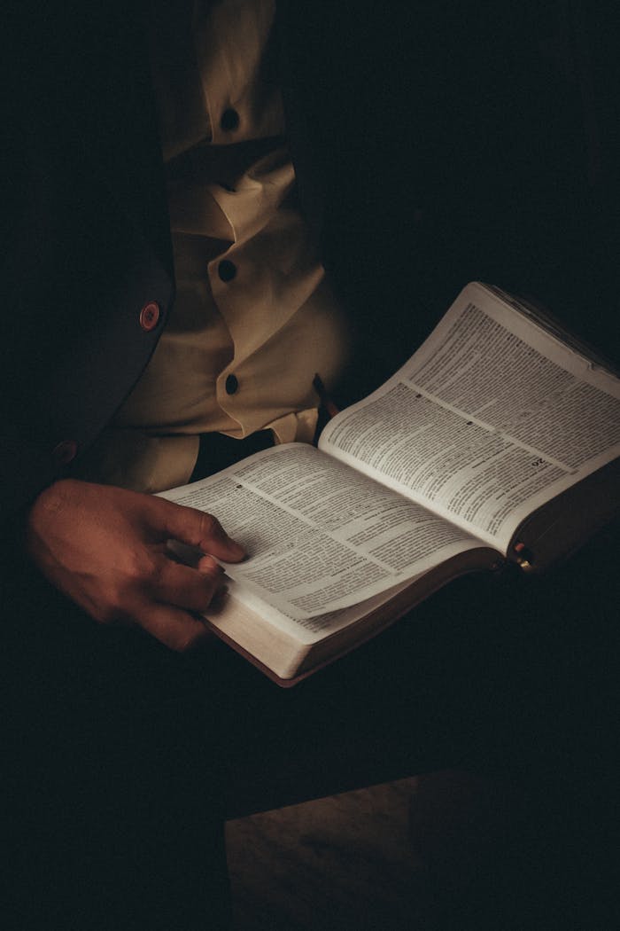 Home A person engaging in thoughtful Bible study, highlighting the intimate exploration of faith and scripture.